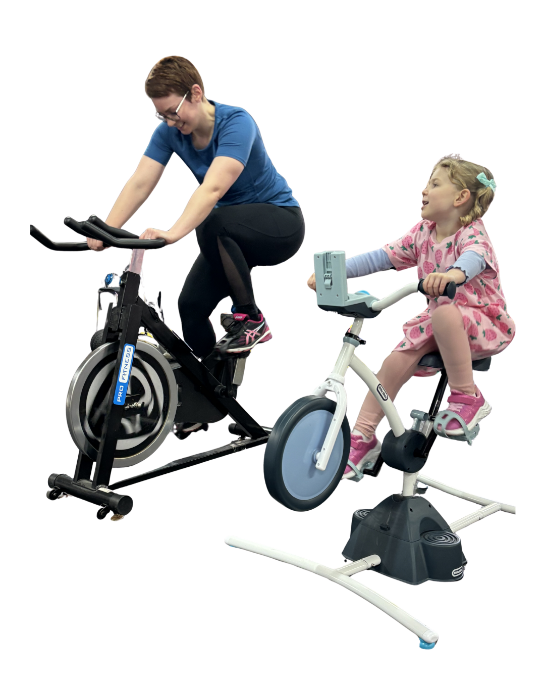 Mam on a spin bike exercising while her daughter rides a toddler bike alongside her